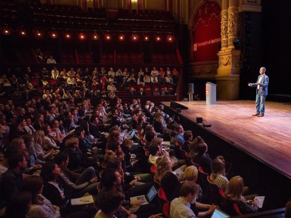 a group of people on a stage in front of a crowd