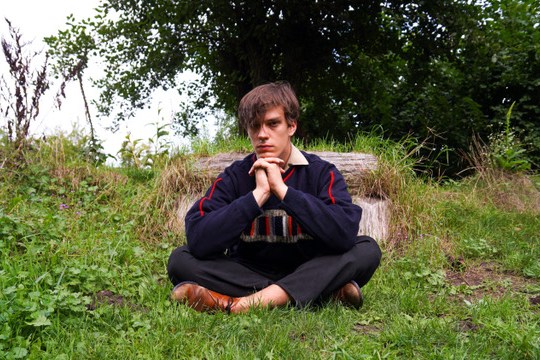 a man sitting in a chair talking on a cell phone