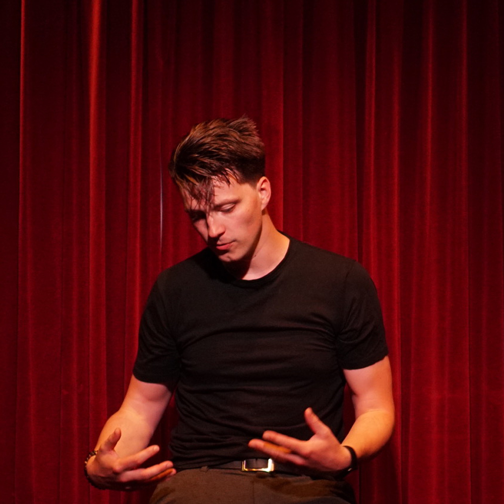 a man standing in front of a curtain