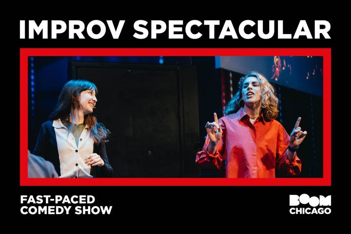 Two performers on stage at an improv comedy show, one speaking animatedly.