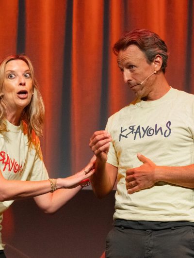Jill Benjamin, Seth Meyers standing in front of a curtain