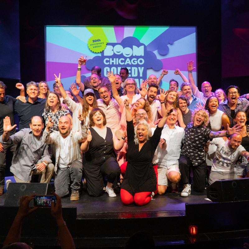 a group of people sitting in front of a crowd posing for the camera