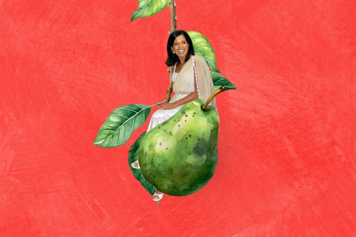 Woman in white dress sitting on a large green pear against a red background.