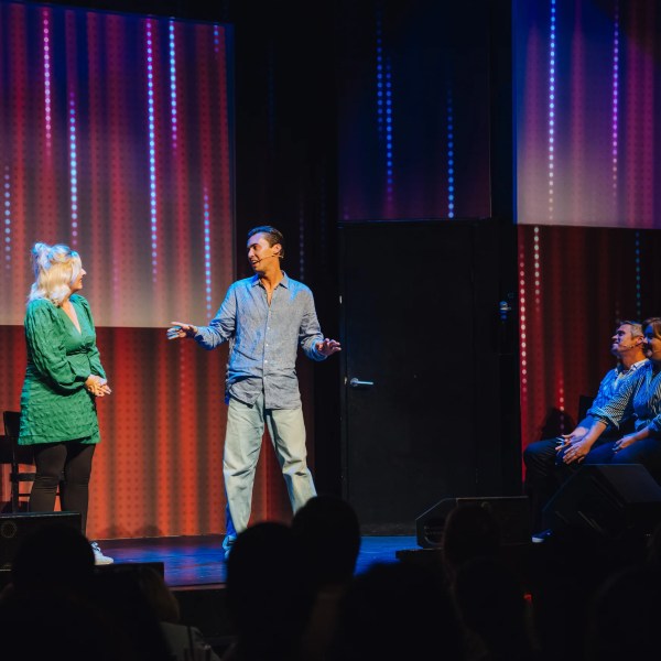 a group of people standing on a stage in front of a curtain