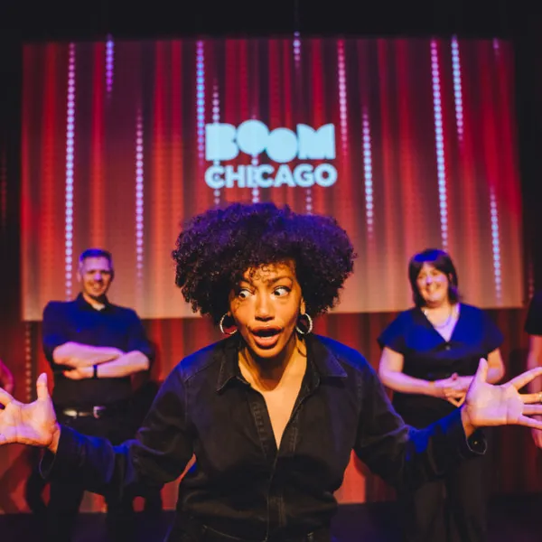 a group of people standing on a stage in front of a curtain