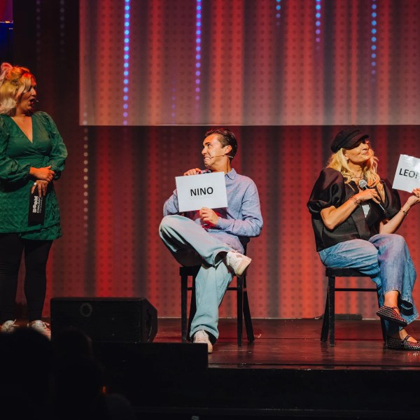 a group of people standing on a stage in front of a curtain