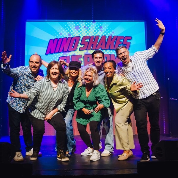 a group of people standing on a stage posing for the camera