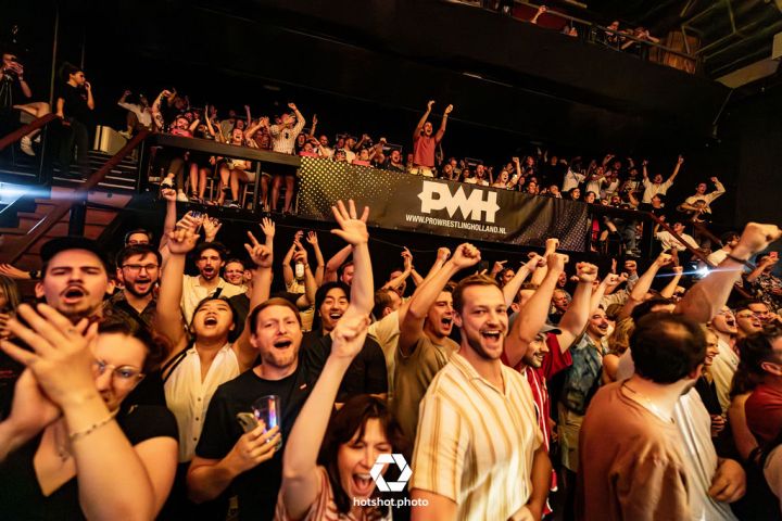a group of people standing in front of a crowd posing for the camera