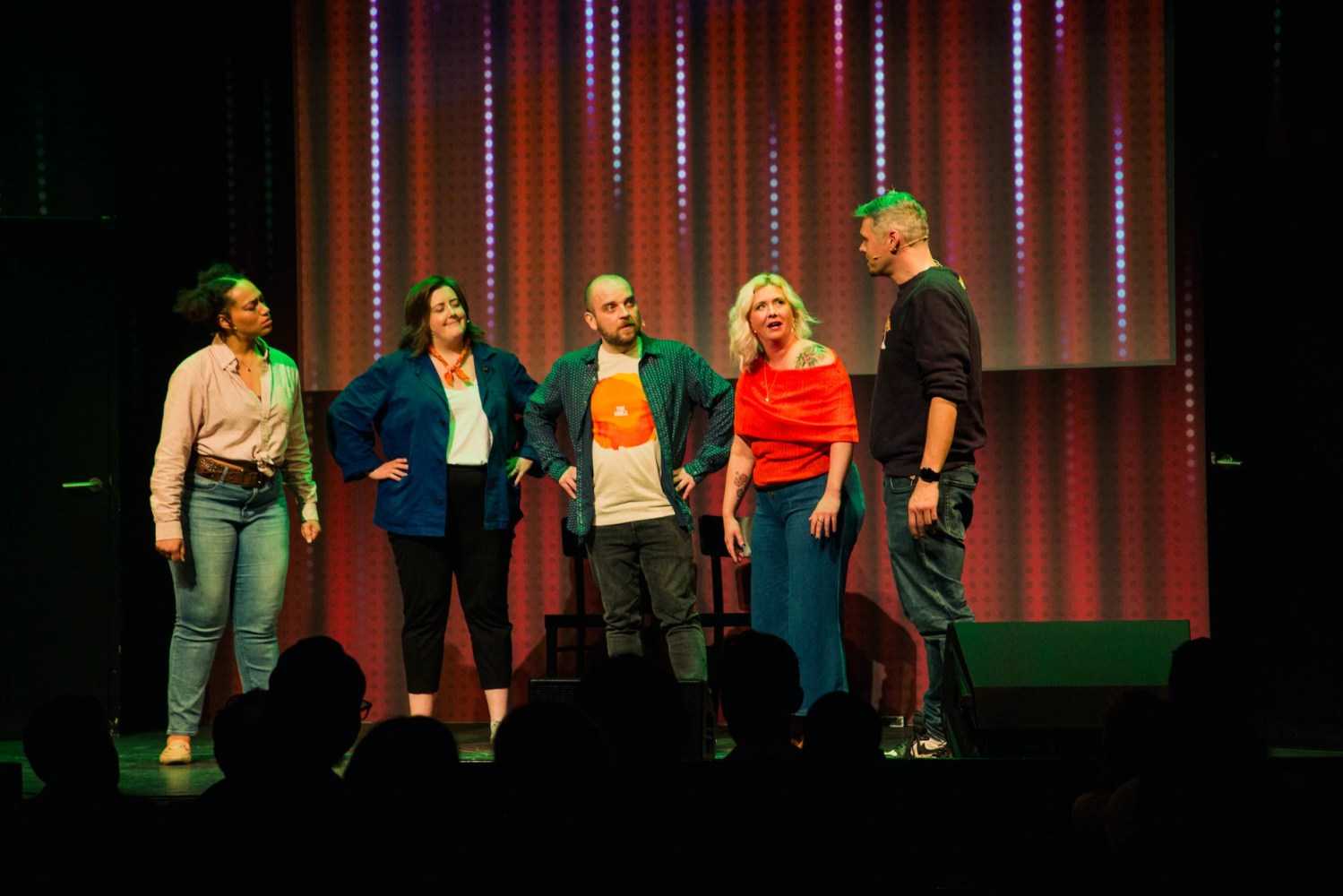 a group of people standing in front of a curtain