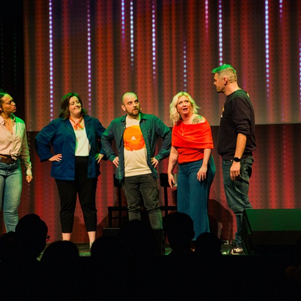 a group of people standing in front of a curtain