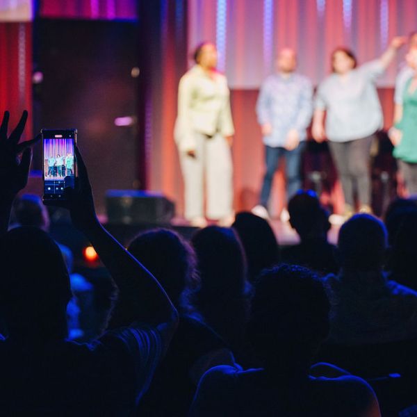 a group of people on a stage in front of a crowd