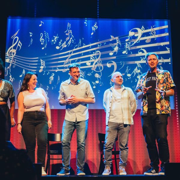 A group of people standing on a stage posing for the camera