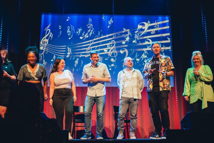 A group of people standing on a stage posing for the camera