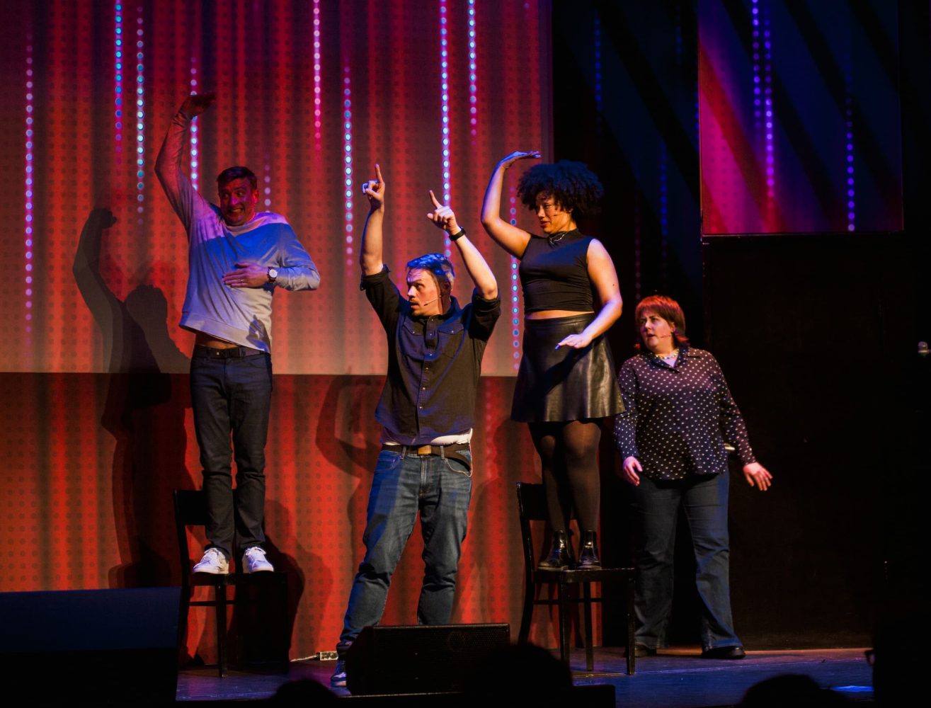 a group of people standing on a stage in front of a curtain