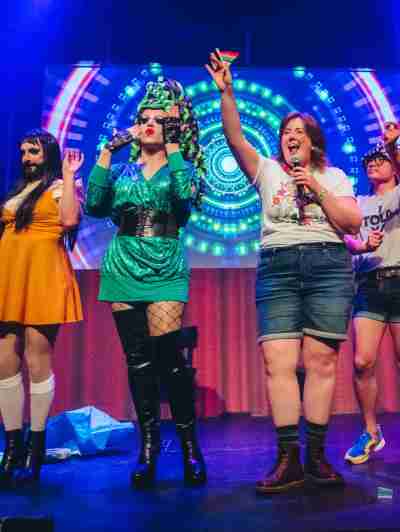 a group of people standing on a stage posing for the camera
