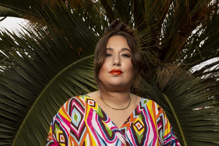 Liza posing in front of a palm tree