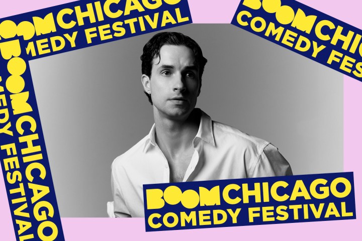 Black and white photo of a man surrounded by Boom Chicago Comedy Festival banners.