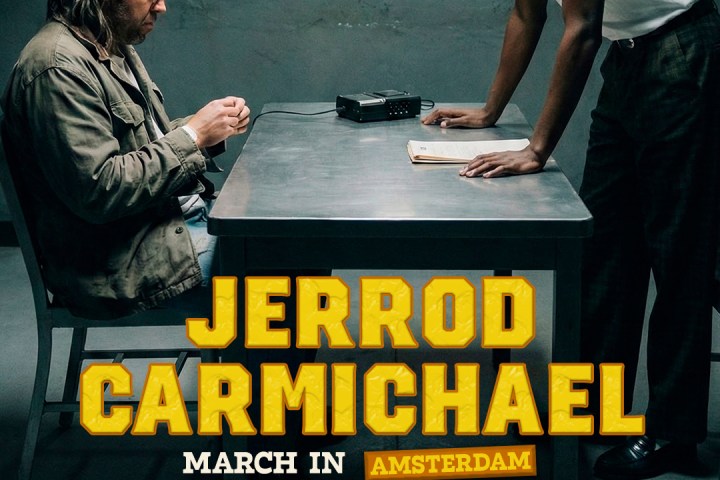 Two men in an interrogation room; ad for Jerrod Carmichael's March 2026 show in Amsterdam.