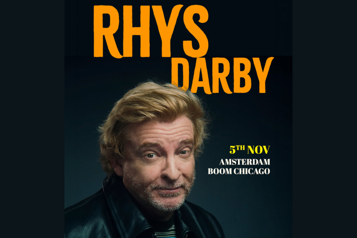 Blonde man with leather jacket, text: 'Rhys Darby, 5th Nov, Amsterdam Boom Chicago'.